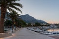 Empty promenade and moored boats in marina in touristic resort Baska Voda, Croatia at dawn in summer Royalty Free Stock Photo