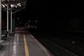 Empty rail road station at night. The train is going on the tracks Royalty Free Stock Photo