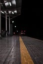 Empty rail road station at night. The train is going on the tracks Royalty Free Stock Photo
