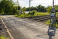 Empty railroad crossing in the countryside, on the road with open barriers. Royalty Free Stock Photo