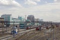 Empty railway tracks on the background of modern trains with cars and city buildings, aerial view