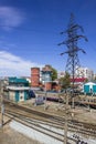 Empty railway tracks on the background of modern trains with cars, power lines, station buildings and the city Royalty Free Stock Photo