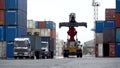 An empty reachstacker travels between containers at a seaport logistics port.