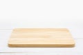 Empty rectangle wooden cutting board on white wooden table.