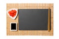 Empty rectangular black slate plate with chopsticks for sushi, ginger and soy sauce on yellow bamboo mat background. Top view with Royalty Free Stock Photo