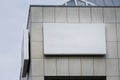 An empty rectangular white sign affixed to the facade of an office building in Germany. This blank display provides ample space