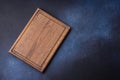 Empty rectangular wooden cutting board on dark concrete background Royalty Free Stock Photo