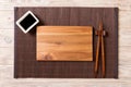 Empty rectangular wooden plate for sushi with sauce and chopsticks on wooden table, top view Royalty Free Stock Photo