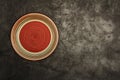 Empty red ceramic dish plate with spiral pattern on gray background. Top view with copy space. Royalty Free Stock Photo