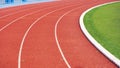 Empty red curve synthetic running tracks and green field in athletic outdoors stadium Royalty Free Stock Photo