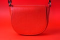 Empty red leather bag on a red background.