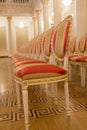 Empty red luxury chairs in the golden ballroom