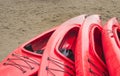 Empty red plastic recreational kayaks for rent or hire, stored on sandy beach after hours on a rainy day. Crescent Beach, Surrey, Royalty Free Stock Photo