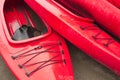 Empty red plastic recreational kayaks for rent or hire, stored on sandy beach after hours on a rainy day. Crescent Beach, Surrey, Royalty Free Stock Photo