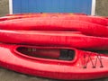 Empty red plastic recreational kayaks for rent or hire, stored on sandy beach after hours on a rainy day. Crescent Beach, Surrey, Royalty Free Stock Photo