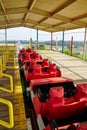 Empty Red Roller Coaster Cars at Rural Amusement Park, Eye-Level View Royalty Free Stock Photo