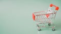 Empty red shopping cart on dark green background with copy space Royalty Free Stock Photo