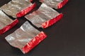 Empty red and silver candy wrappers on a black background. Crump Royalty Free Stock Photo