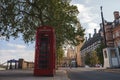 Empty red telephone booth and tree on sidewalk with famous Big Ben in background