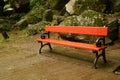 Empty red wooden park bench in the light rain Royalty Free Stock Photo