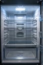 Empty refrigerator with open doors and bright light. Royalty Free Stock Photo