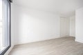 Empty residential building room with white fitted wardrobes and window Royalty Free Stock Photo
