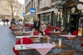 Empty restaurant and some people at a Marienplatz in front of the Munich old town hall in Munich, Germany