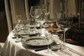 Empty restaurant table. Table setting for a holiday. Empty wine glasses and dishes in the golden sunlight. Royalty Free Stock Photo