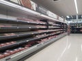 Empty retail shop shelves in chiller meat section in supermarket. Low supplies due to stockpiling by customers consumers