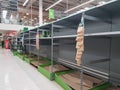 Empty retail shop shelves in supermarket.  Low supplies due to stockpiling by customers consumers due to covid 19 coronavirus Royalty Free Stock Photo