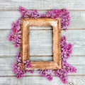 Empty retro wooden frame with spring branches of lilac flowers on a background of worn wooden white boards in a rustic Royalty Free Stock Photo