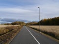 Empty road amidst field against sky