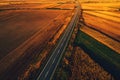 Empty road through countryside in autumn sunset, aerial view Royalty Free Stock Photo