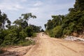 Empty road in forest and lonely tourist. Road construction site in green nature. Tropical island development. Royalty Free Stock Photo