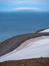 an empty road goes down to the coast on a clear day