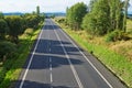 An empty road lined with trees in the landscape