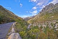 Empty road in the mountains with a cloudy blue sky. Landscape of a countryside roadway for traveling on a mountain pass Royalty Free Stock Photo