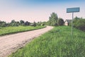 empty road with sign for village name - retro vintage look Royalty Free Stock Photo