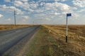 Empty road in the steppe and kilometer sign 1001