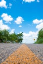 Empty road surrounded by trees, at the end, a traffic sign. Beautiful blue sky Royalty Free Stock Photo