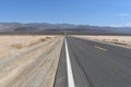 Empty road in the Valley of death, road in the hot desert against the backdrop of mountains, US national park Royalty Free Stock Photo