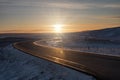 Empty road in the winter landscape of Iceland with sunset