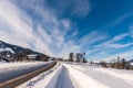 Blue cloudy sky, big snow covered fields and empty road in winter, sunny day. Royalty Free Stock Photo