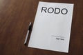 Empty RODO document on wooden desk with pen.