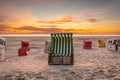 Roofed wicker beach chairs at a beach at Langeoog at the north sea with beautiful sunset Royalty Free Stock Photo