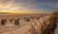 Roofed wicker beach chairs at a beach at Langeoog at the north sea with sunset