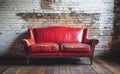 In an empty room with a brick wall, a 3D rendering shows an old red leather sofa Royalty Free Stock Photo