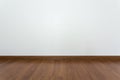 Empty room with brown wood laminate floor and white mortar wall Royalty Free Stock Photo