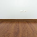 Empty room with brown wood laminate floor and white mortar wall Royalty Free Stock Photo