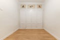Empty room with fitted wardrobes with white wooden doors on the wall Royalty Free Stock Photo